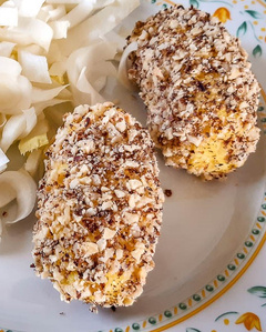 KI generiert: Das Bild zeigt ein gebackenes Gericht aus Kartoffeln und möglicherweise weiteren Zutaten wie Zwiebeln und Gemüse in einer rechteckigen Form. Eine Gabel und ein Löffel liegen darauf.