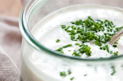 KI generiert: Das Bild zeigt ein gebackenes Gericht aus Kartoffeln und möglicherweise weiteren Zutaten wie Zwiebeln und Gemüse in einer rechteckigen Form. Eine Gabel und ein Löffel liegen darauf.