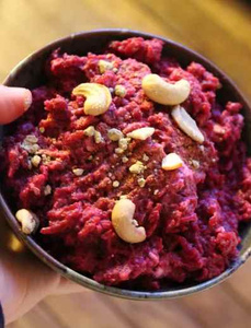 KI generiert: Das Bild zeigt ein gebackenes Gericht aus Kartoffeln und möglicherweise weiteren Zutaten wie Zwiebeln und Gemüse in einer rechteckigen Form. Eine Gabel und ein Löffel liegen darauf.