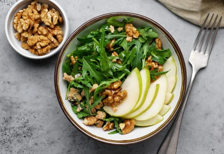 KI generiert: Das Bild zeigt ein gebackenes Gericht aus Kartoffeln und möglicherweise weiteren Zutaten wie Zwiebeln und Gemüse in einer rechteckigen Form. Eine Gabel und ein Löffel liegen darauf.