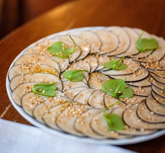 KI generiert: Das Bild zeigt ein gebackenes Gericht aus Kartoffeln und möglicherweise weiteren Zutaten wie Zwiebeln und Gemüse in einer rechteckigen Form. Eine Gabel und ein Löffel liegen darauf.