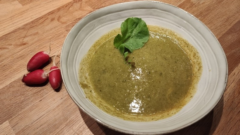 KI generiert: Das Bild zeigt ein gebackenes Gericht aus Kartoffeln und möglicherweise weiteren Zutaten wie Zwiebeln und Gemüse in einer rechteckigen Form. Eine Gabel und ein Löffel liegen darauf.