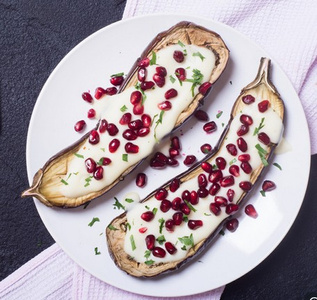 KI generiert: Das Bild zeigt ein gebackenes Gericht aus Kartoffeln und möglicherweise weiteren Zutaten wie Zwiebeln und Gemüse in einer rechteckigen Form. Eine Gabel und ein Löffel liegen darauf.