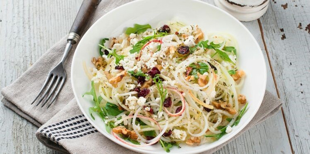 KI generiert: Das Bild zeigt ein gebackenes Gericht aus Kartoffeln und möglicherweise weiteren Zutaten wie Zwiebeln und Gemüse in einer rechteckigen Form. Eine Gabel und ein Löffel liegen darauf.