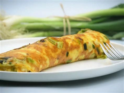 KI generiert: Das Bild zeigt ein gebackenes Gericht aus Kartoffeln und möglicherweise weiteren Zutaten wie Zwiebeln und Gemüse in einer rechteckigen Form. Eine Gabel und ein Löffel liegen darauf.