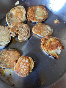 KI generiert: Das Bild zeigt ein gebackenes Gericht aus Kartoffeln und möglicherweise weiteren Zutaten wie Zwiebeln und Gemüse in einer rechteckigen Form. Eine Gabel und ein Löffel liegen darauf.