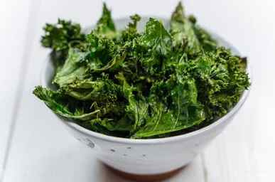 KI generiert: Das Bild zeigt ein gebackenes Gericht aus Kartoffeln und möglicherweise weiteren Zutaten wie Zwiebeln und Gemüse in einer rechteckigen Form. Eine Gabel und ein Löffel liegen darauf.