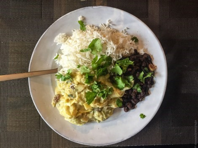 KI generiert: Das Bild zeigt ein gebackenes Gericht aus Kartoffeln und möglicherweise weiteren Zutaten wie Zwiebeln und Gemüse in einer rechteckigen Form. Eine Gabel und ein Löffel liegen darauf.