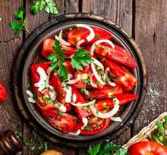 KI generiert: Das Bild zeigt ein gebackenes Gericht aus Kartoffeln und möglicherweise weiteren Zutaten wie Zwiebeln und Gemüse in einer rechteckigen Form. Eine Gabel und ein Löffel liegen darauf.