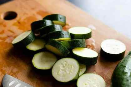 KI generiert: Das Bild zeigt ein gebackenes Gericht aus Kartoffeln und möglicherweise weiteren Zutaten wie Zwiebeln und Gemüse in einer rechteckigen Form. Eine Gabel und ein Löffel liegen darauf.